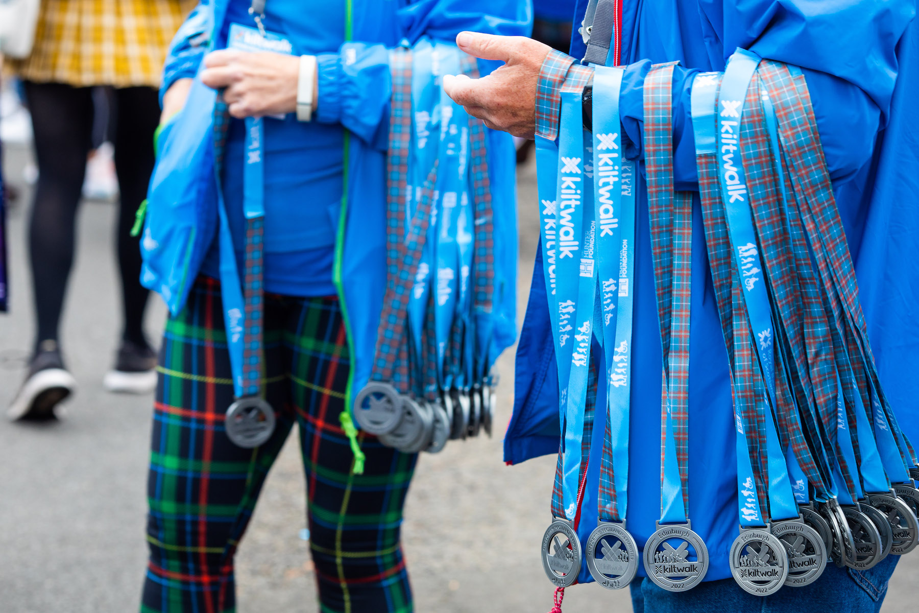 KiltWalk Two people with kiltwalk medals draped over their forearms