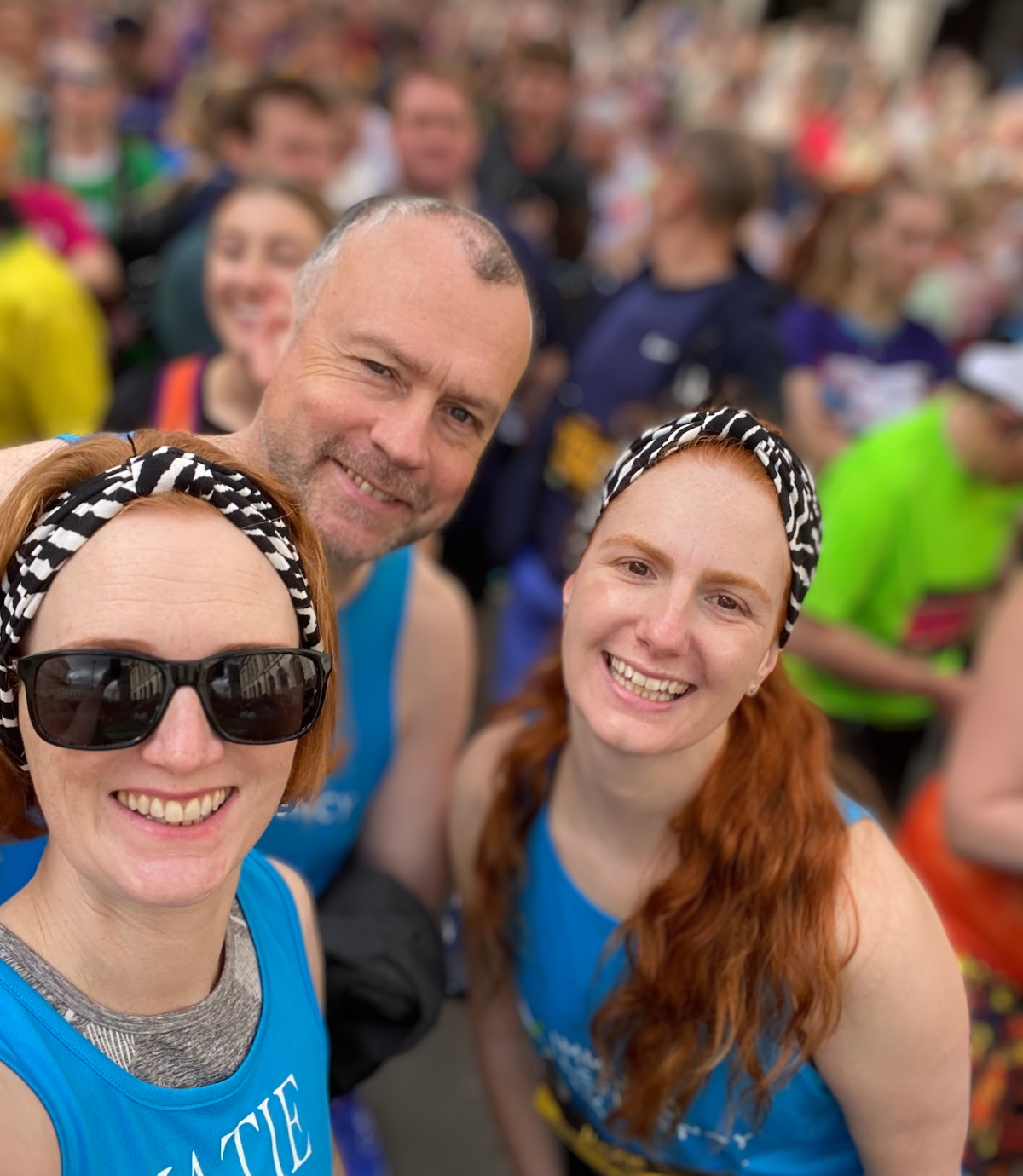 a man and two women smiling after completing a half marathon